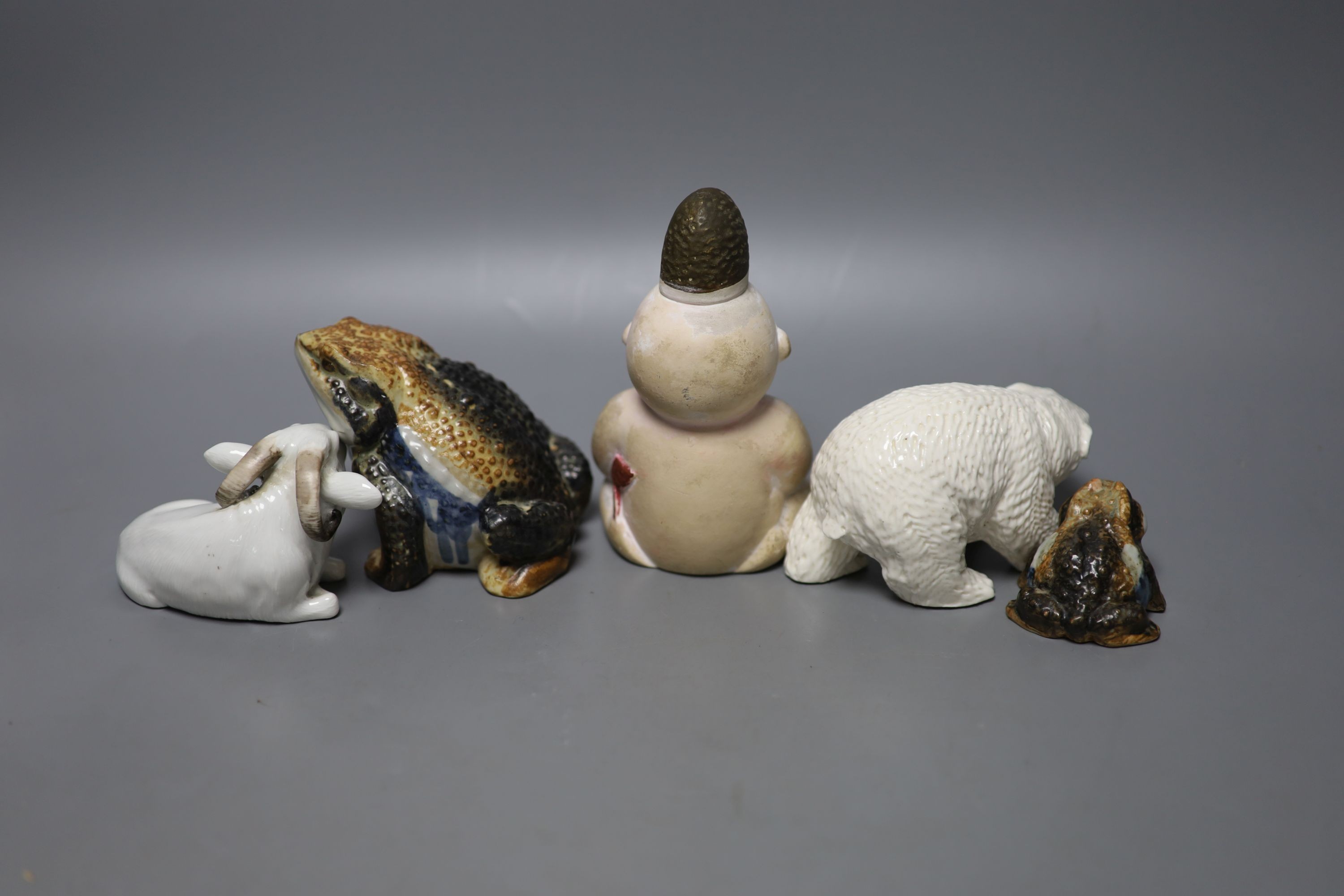 A Japanese Hirado porcelain figure of a polar bear, a Japanese porcelain figure of a ram, two figures of toads and a doll figure